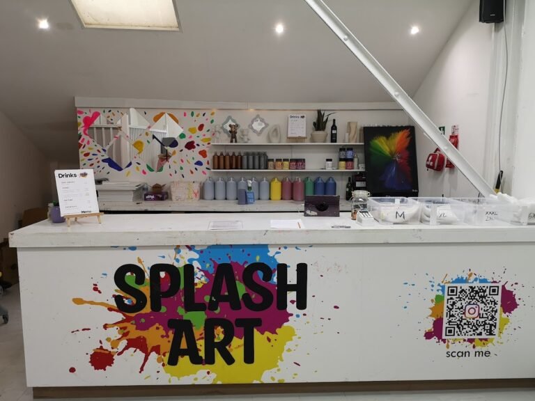 The colorful front reception counter at the Splash Art Liverpool studio showing the main brand logo and display shelves.