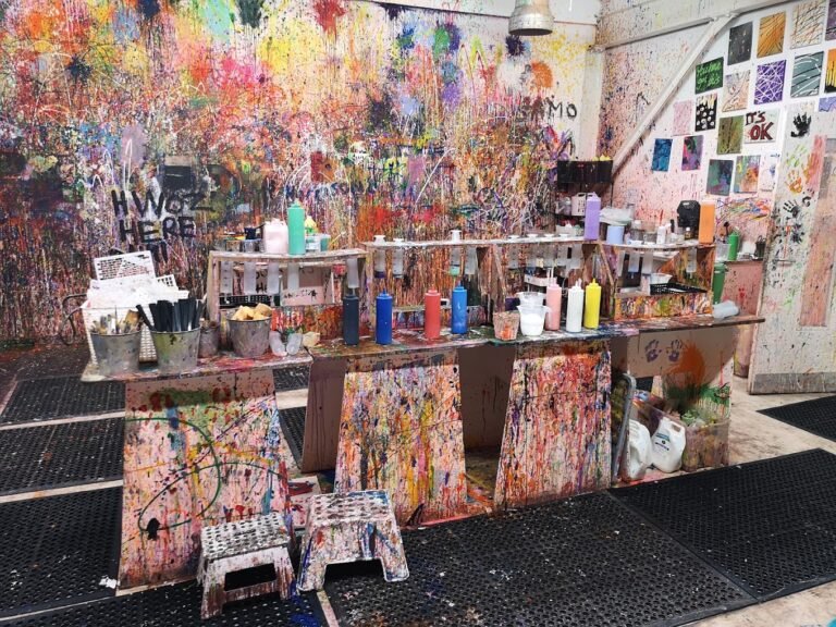 Squeeze bottles and paint syringes lined up on a splattered counter at an immersive art studio Liverpool. And an amazing Liverpool Day out